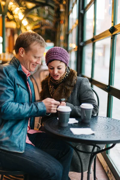 Attractive Caucasian Couple Sitting Cafe Drinking Coffee Using Handheld Smartphone — ストック写真