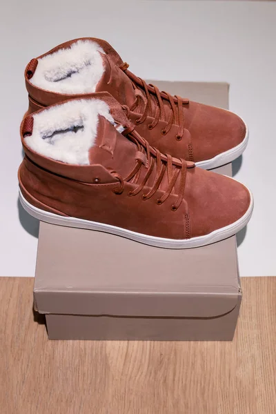 Zapatillas de deporte de nobuck de moda marrón entregadas en una caja a un cliente a través de un pedido en línea. Compras —  Fotos de Stock