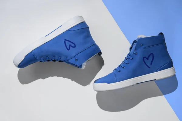 Zapatillas de deporte unisex en ante azul sobre fondo azul y blanco, vista superior, plano, copyspace —  Fotos de Stock