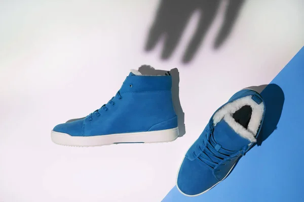 Zapatillas unisex azul sobre fondo gráfico blanco y sombra dibujada a mano desde arriba, planas —  Fotos de Stock