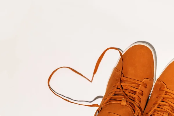 Unisex brown winter sneakers on a white and blue background. Heart made of shoe drawers. Concept - love for comfort, copyspase — Stock Photo, Image