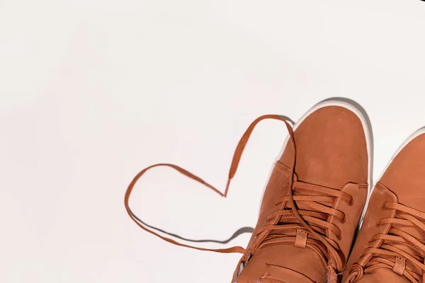 Unisex brown winter sneakers on a white and blue background. Heart made of shoe drawers. Concept - love for comfort, copyspase — Stock Photo, Image