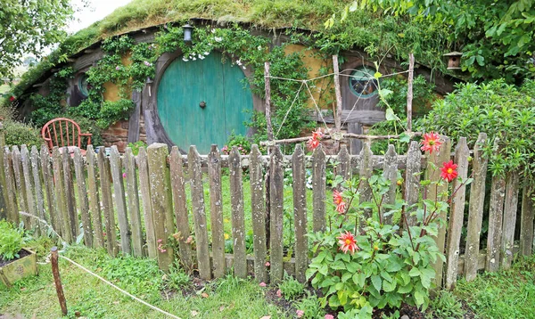 Hobbit-Haus mit roten Dahlienblüten — Stockfoto