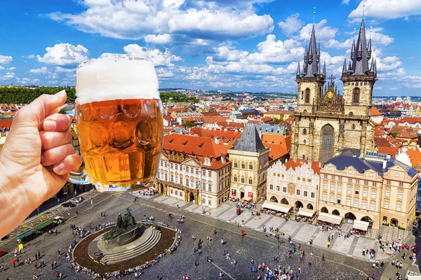 Hand mit einem Krug Bier auf dem Hintergrund des Altstadtplatzes — Stockfoto