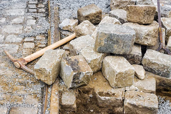 Cobblestone tien päällystämiseen ja pickax — kuvapankkivalokuva