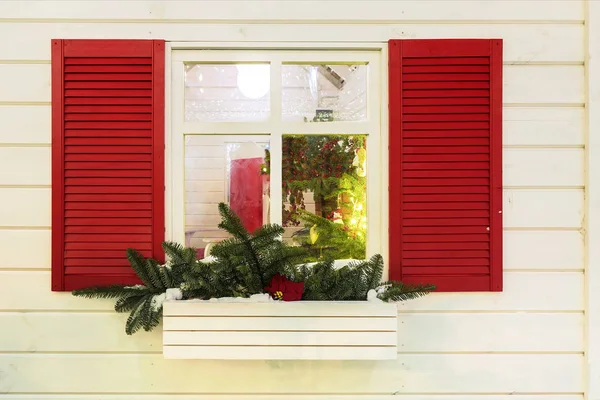 Вікно з червоними віконницями, прикрашеними на Різдво — стокове фото