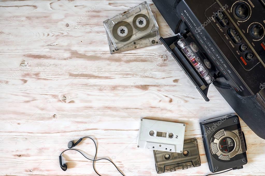 cassette player, cassette recorder and audio tape on a wooden ba