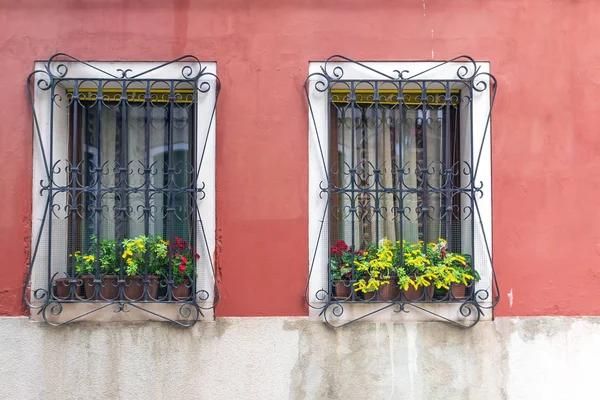 Окно с цветами и решетками на окнах — стоковое фото