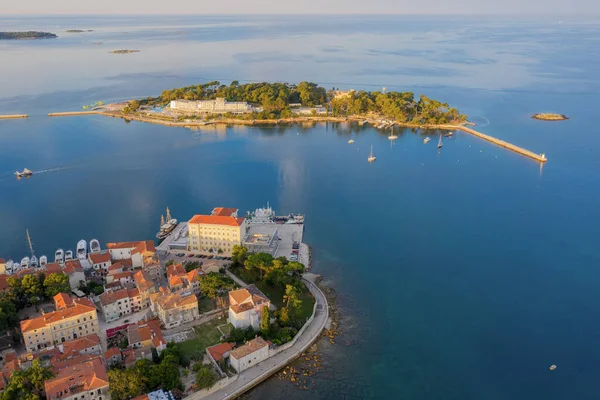An island with a hotel complex in the Adriatic sea opposite the old town of Porec in Croatia. Shooting from a drone.
