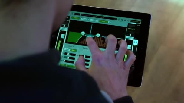 엔지니어는 위에서 촬영한 태블릿의 프로그램을 사용하여 그룹의 연주를 조정한다 — 비디오
