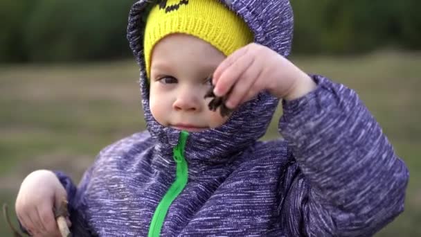 Ett Barn Pojke Klädd Höst Jacka Och Huva Håller Klump — Stockvideo