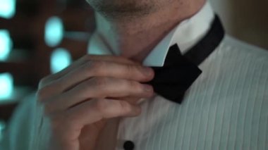 Bir adamın eli siyah bir kelebeği tutuyor, kelebeği çıkarıyor ve elini aşağı indiriyor, yakın çekim, yavaş çekim, odak dışı.