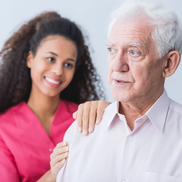 Female carer assisting senior man — Stock Photo, Image