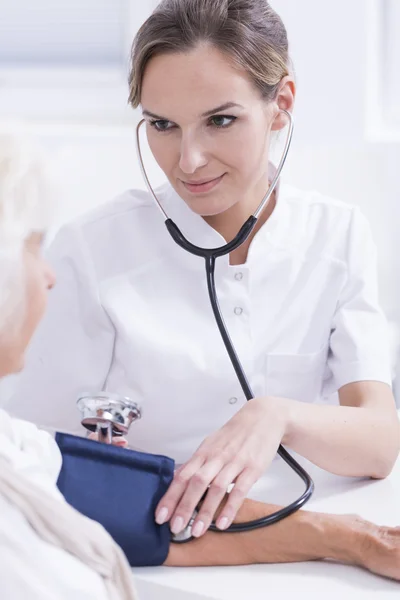 Médico midiendo la presión arterial — Foto de Stock