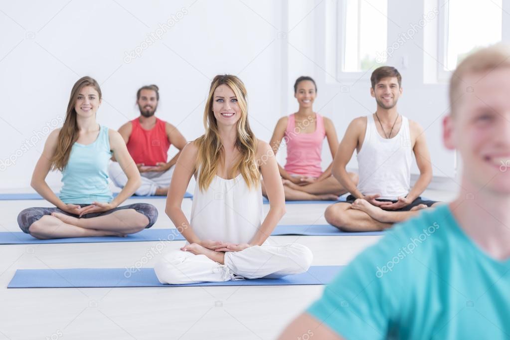 Smiled young people meditating