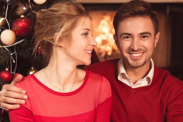 Pareja sentada junto a la chimenea — Foto de Stock