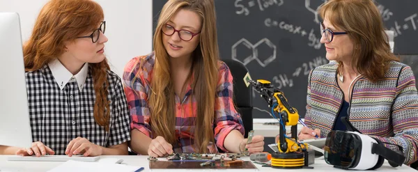 Estudantes e professor construindo um braço robótico — Fotografia de Stock