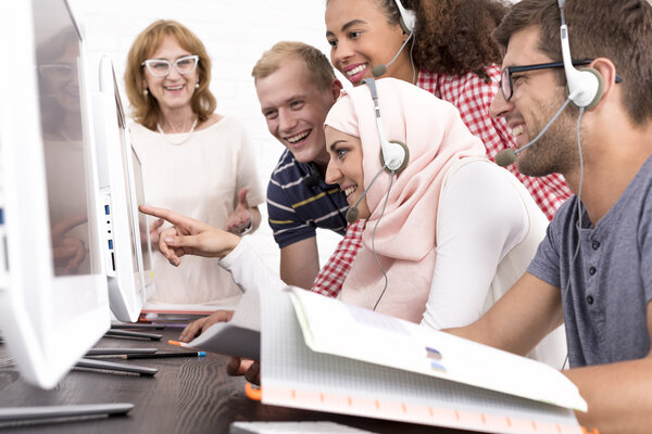 Smiled students looking at the monitor screen