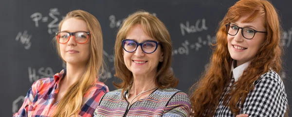 Mature professor and two young students — Stockfoto