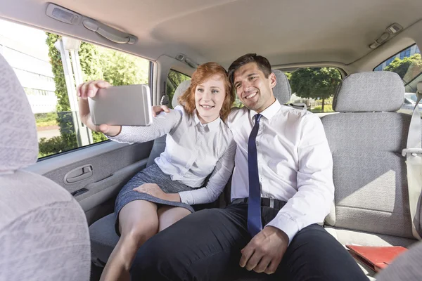 Des hommes d'affaires prenant un selfie sur un siège arrière dans un taxi — Photo