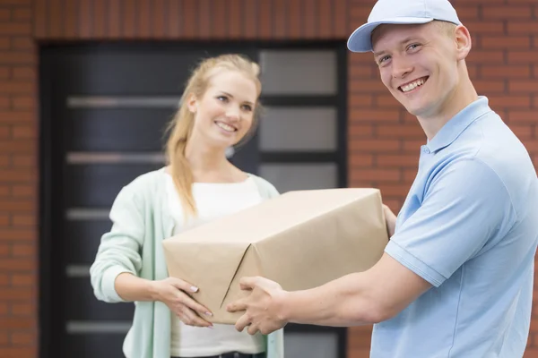 Correio entregando um pacote para o cliente — Fotografia de Stock