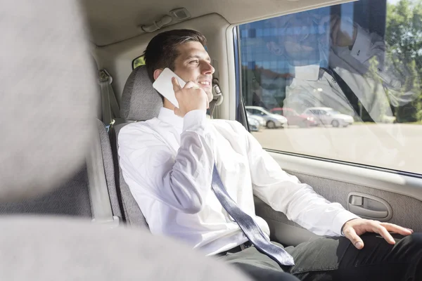 Uomo d'affari che parla al telefono in macchina — Foto Stock