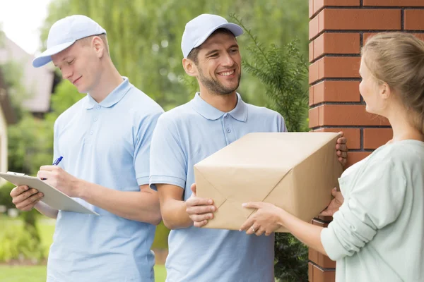 Courier levering van een perceel aan een jonge vrouw — Stockfoto