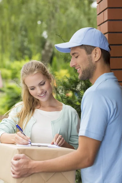 Correo profesional con el cliente firmando un formulario de entrega — Foto de Stock