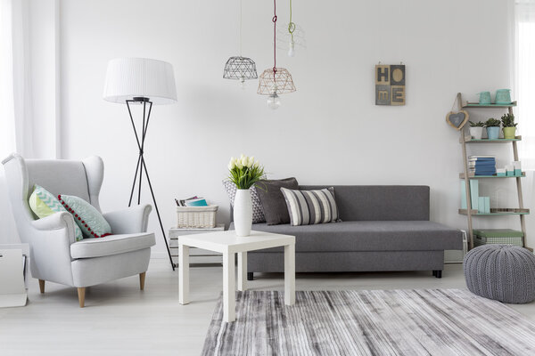 Современный интерьер гостиной с серым креслом
