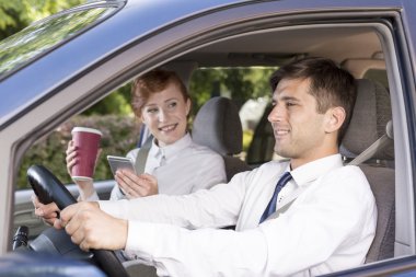 Bir taksi şoförü gülümseyen genç iş kadını