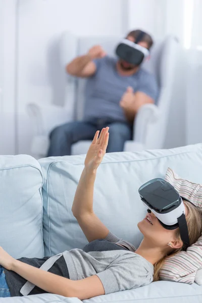 Woman lying on bed wearing VR glasses