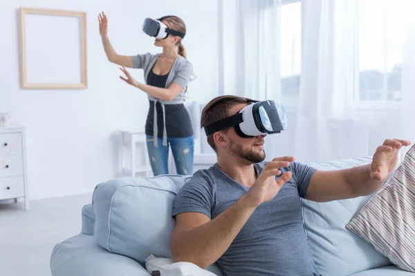 Pareja relajándose en casa usando gafas VR — Foto de Stock