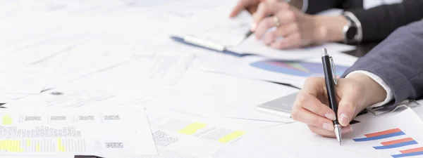 Desk full of documents and businesswomen taking notes there — Stock Photo, Image