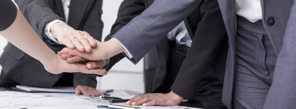 Деловые женщины кладут руки друг на друга
