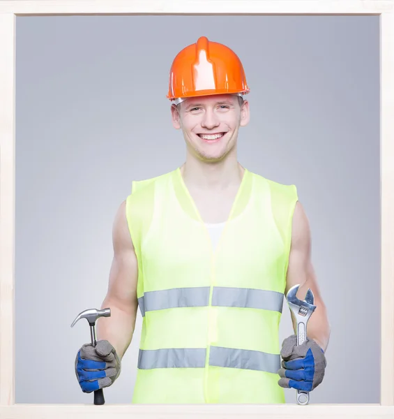 Lächelnder Arbeiter, der das Werkzeug behält — Stockfoto