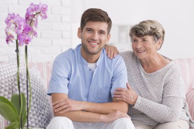 Onun genç ve gülümsüyor caregiver ile üst düzey kadın