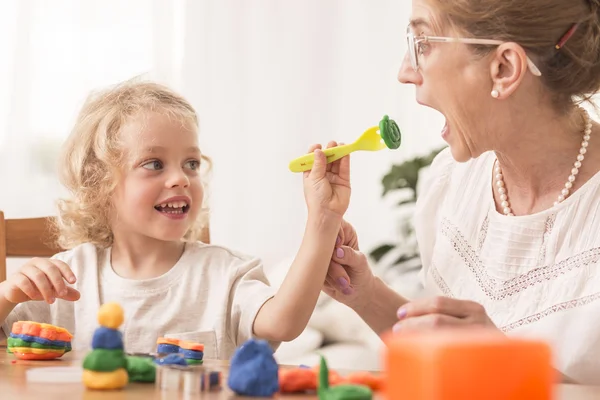 Flicka som leker med mormor — Stockfoto