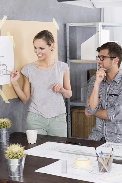 Woman is showing something on a drawing — Stock Photo, Image