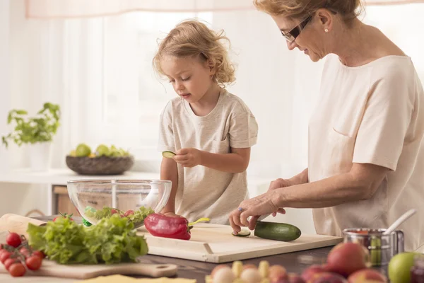 Sênior babá cozinhar com criança — Fotografia de Stock