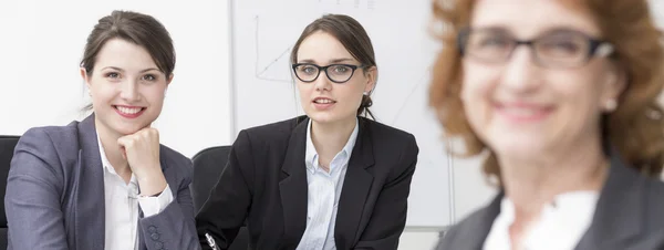 Vrouwelijke ondernemers zitten in hun kantoor en glimlachen — Stockfoto