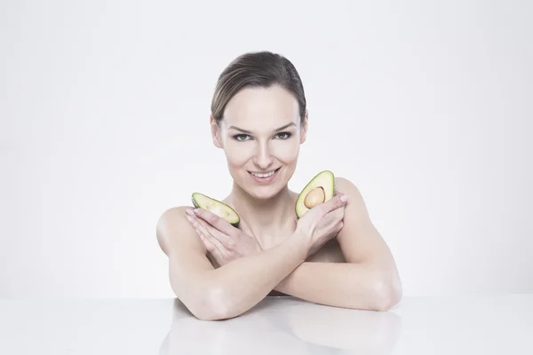 Jovem mulher mantendo abacate — Fotografia de Stock