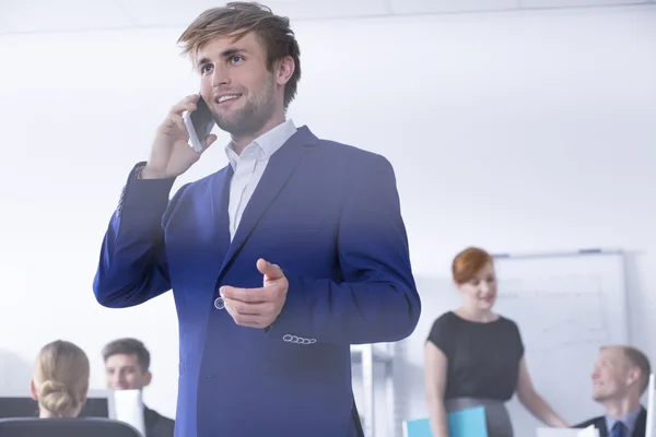 Homme en costume parlant au téléphone au bureau — Photo