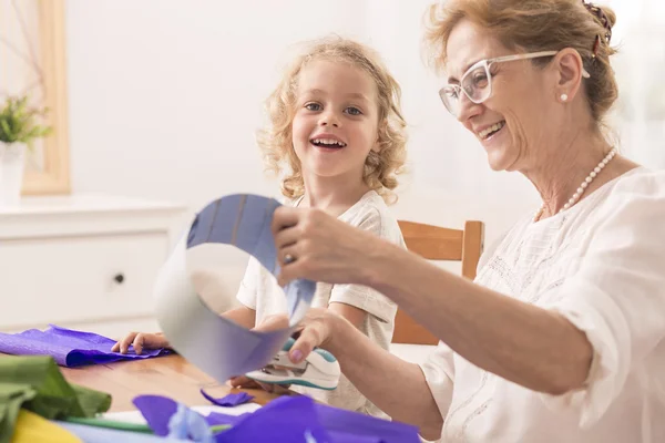 Grandmother making paper cuts — Stock Photo, Image