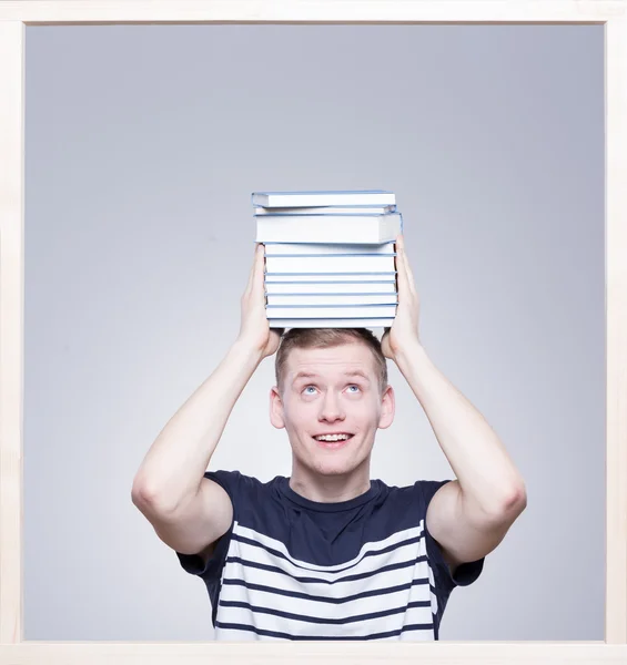 Estudante mantendo livros em sua cabeça — Fotografia de Stock