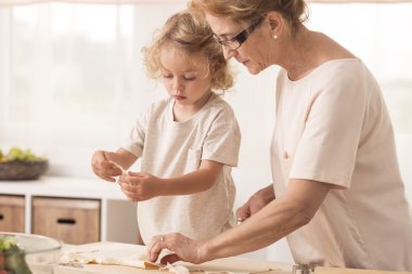 Grandmother making cookies with grandchild clipart