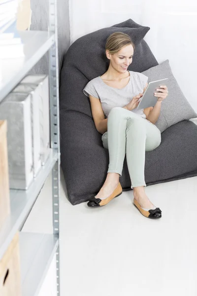 Vrouw zit op moderne poef — Stockfoto