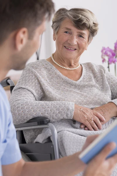 Krankenschwester und ältere Frau im Rollstuhl — Stockfoto