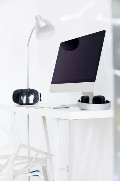 Modern desktop with monitor screen an earphones — Stock Photo, Image