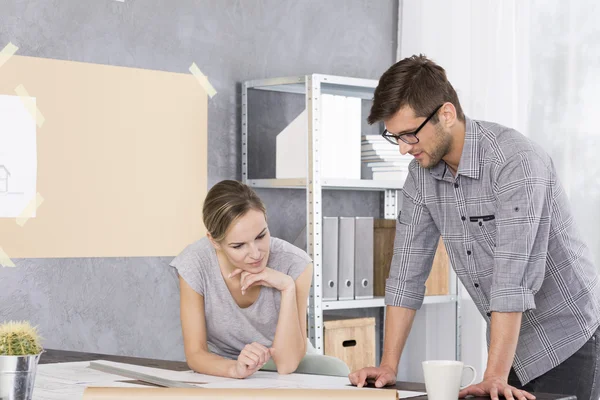 Vrouw en man kijken naar project papers — Stockfoto