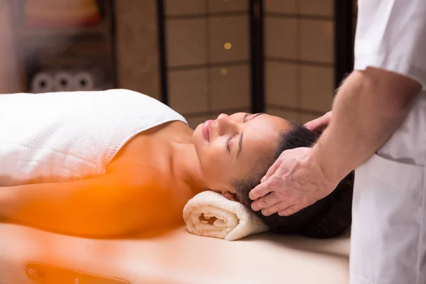 Mulher relaxante durante a massagem na cabeça — Fotografia de Stock